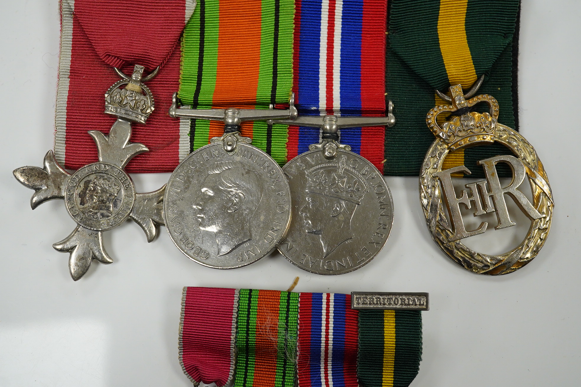 A group of 4 medals including MBE in display case